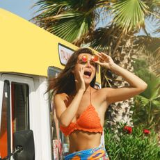 woman wearing orange crochet top at the beach