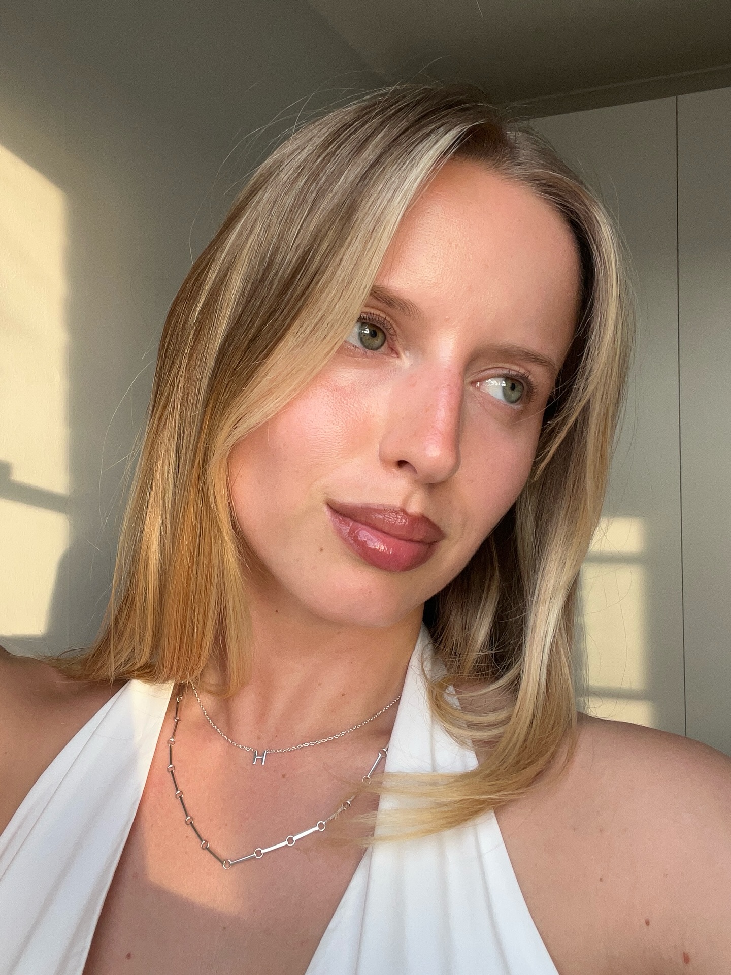 Photo of a woman taking a selfie wearing a white tank top