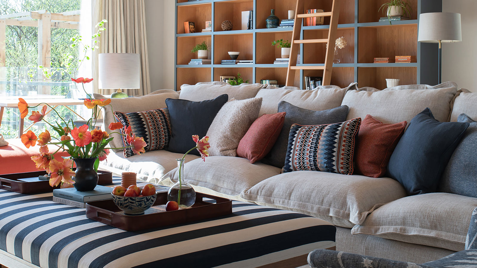 cosy family living room with grey sofa and built-in shelving with ladder