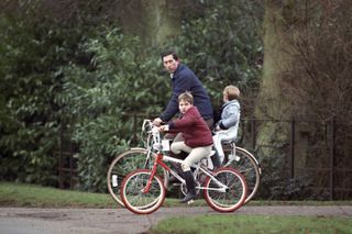 Prince Charles, Prince William And Prince Harry On Bikes Returning From The Stables, At Sandringham Estate, In Norfolk