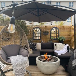 garden decking area with swing chair and fire bowls