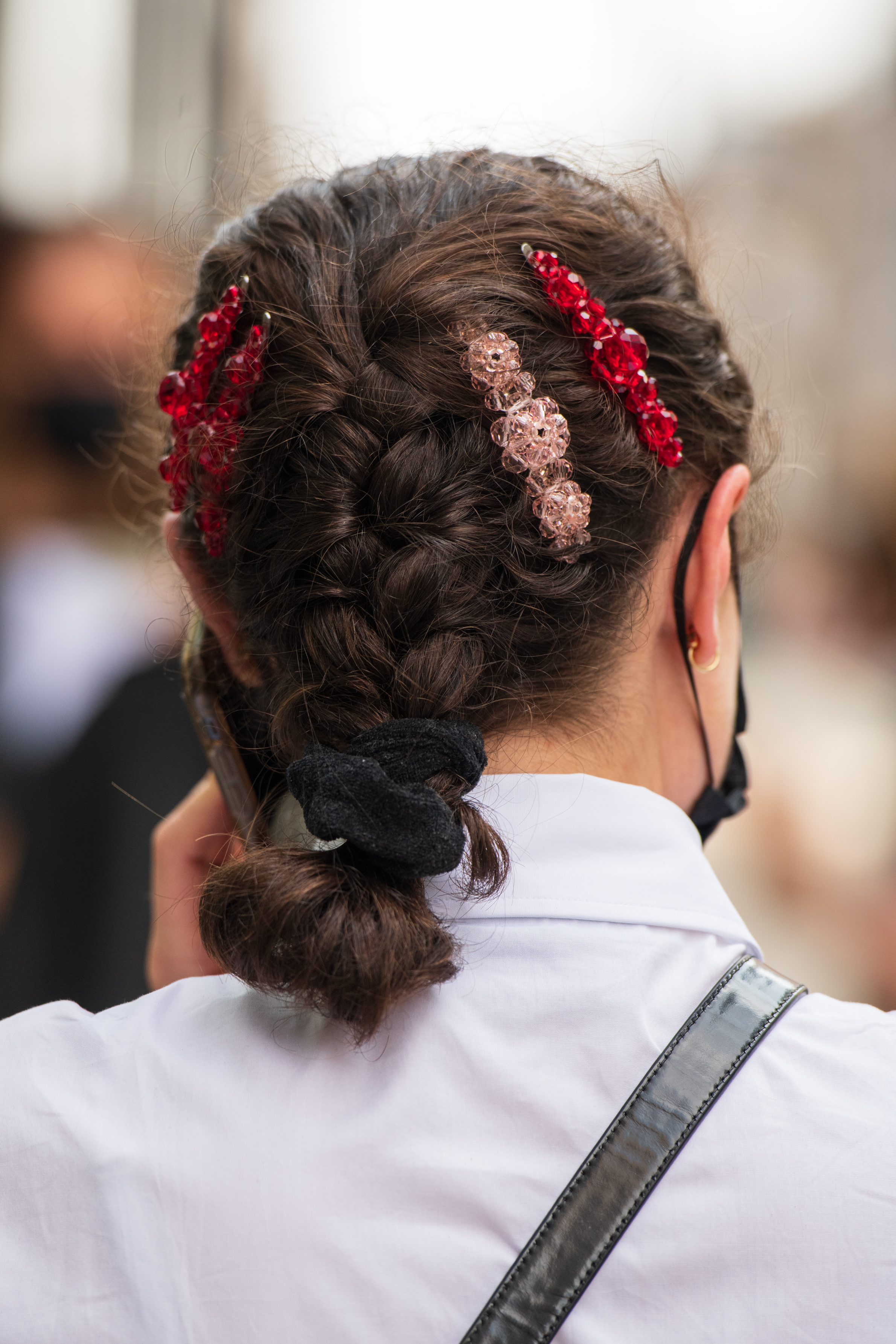 person with a braided hairstyle decorated with four bubble bobby pins