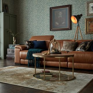 living room with designed wall brown sofa with designed cushion brown flooring and lamp