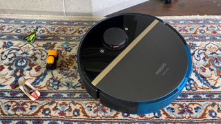 Philips HomeRun 7000 Series Aqua Vacuum and Mop Robot avoiding toy cars on a rug