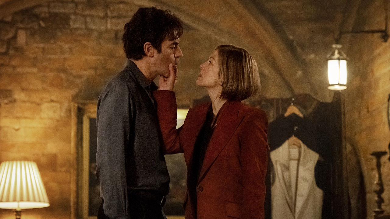 Sacha Baron Cohen as Damien Sachs and Rosamund Pike as Alex Fox in Ladies First.