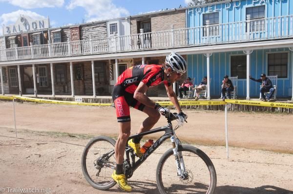 Colin Cares (Kenda Felt) rides by the old ghost town