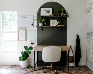 Home office set-up with black painted arch and white swivel chair.