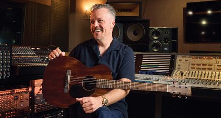 Jason Isbell smiles as he is photographed in the studio with his new signature Martin acoustic.