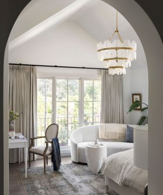 bedroom seen through arched doorway with white sofa
