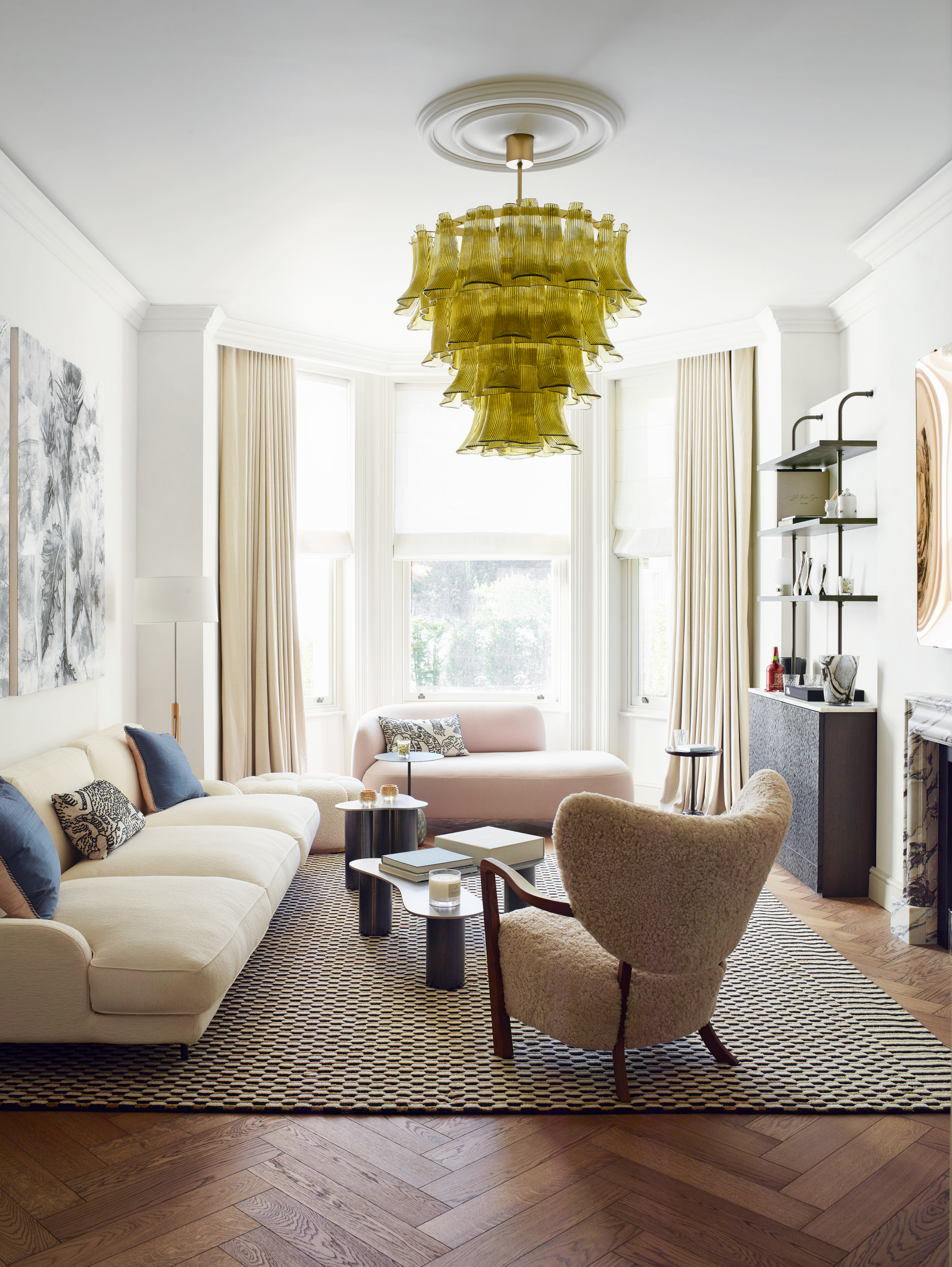 White living room with cream sofa, pale pink daybed, beige boucle armchair and black and white check rug