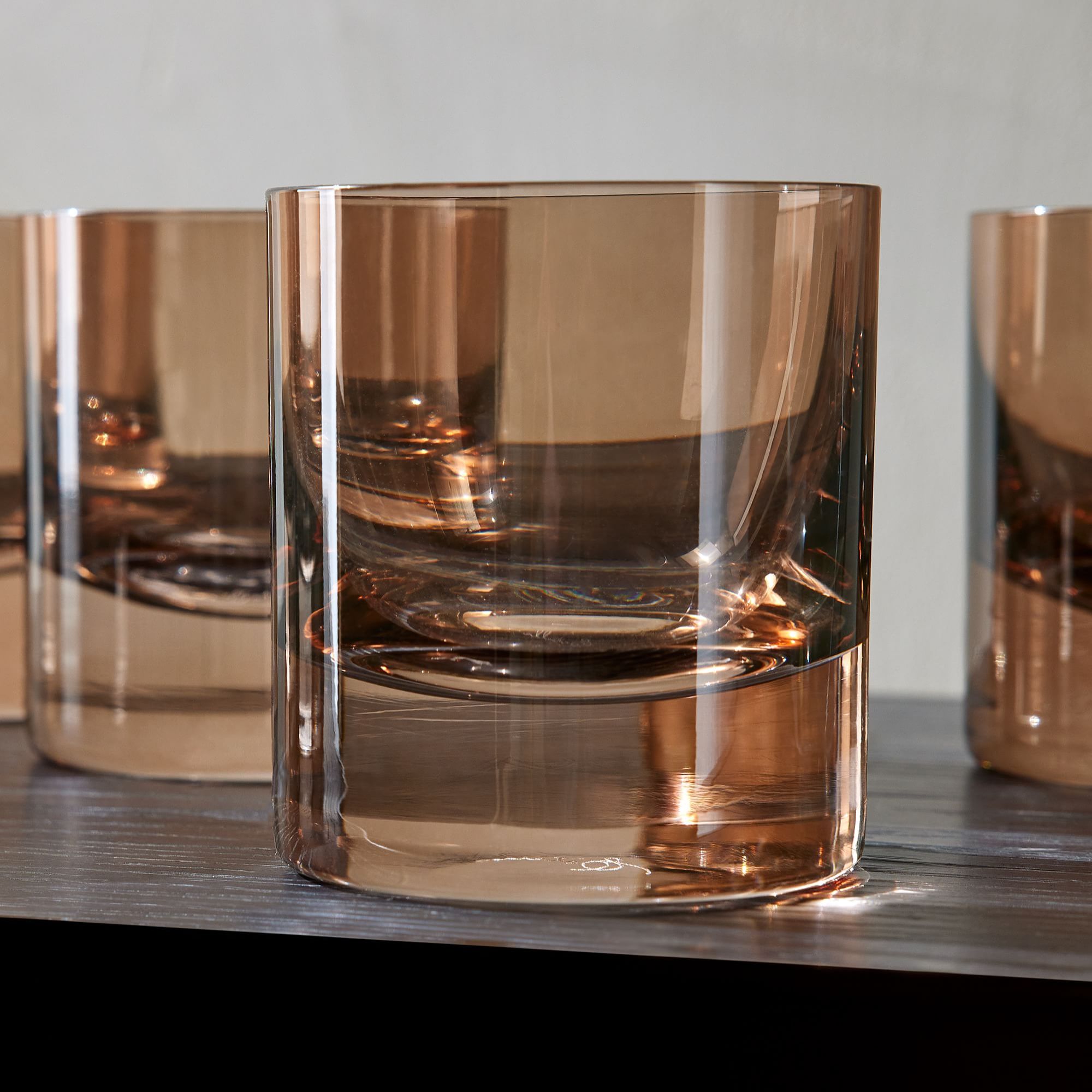 Amber old fashioned glasses on black shelf