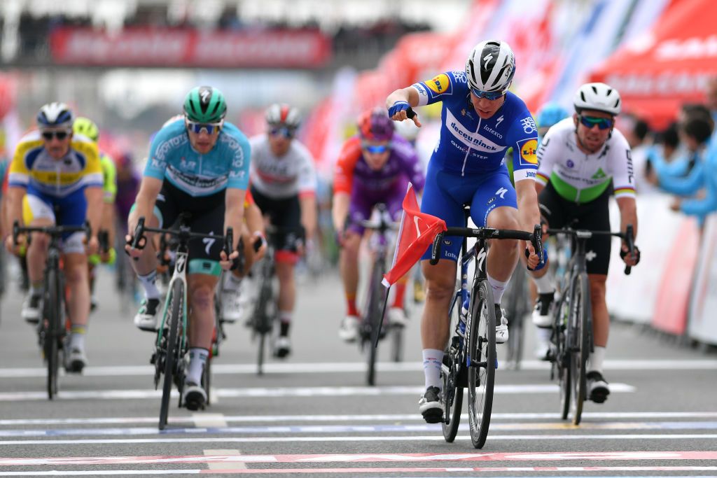Fabio Jakobsen drops a Turkish flag on the ground after winning stage 3 of the Tour of Turkey