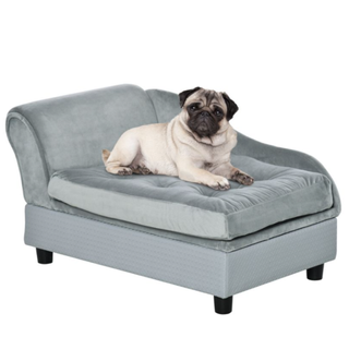 A pug sitting on top of a plush pet bed