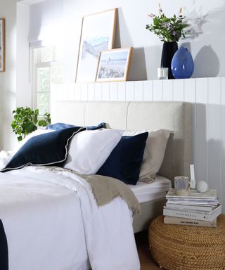 Blue and white bedroom decor with shelf above headboard