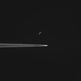 An image of Enceladus and Saturn's rings captured by the Cassini spacecraft.