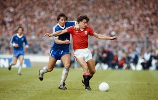 Manchester United's Kevin Moran is challenged by Brighton's Michael Robinson in the 1983 FA Cup final.