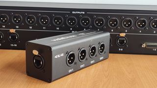 The Violet Audio io44 four-channel XLR-to-Ethercon adapter (foreground) and the DX16B 16-channel passive audio splitter (behind).