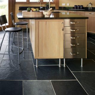 Kitchen with marble countertop and black flooring