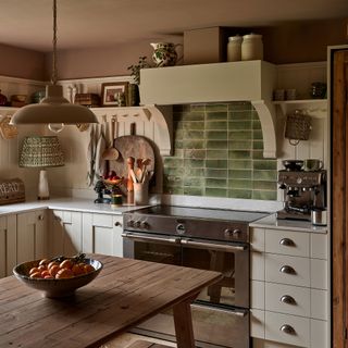 Green splashback with white cabinets and pendant lights