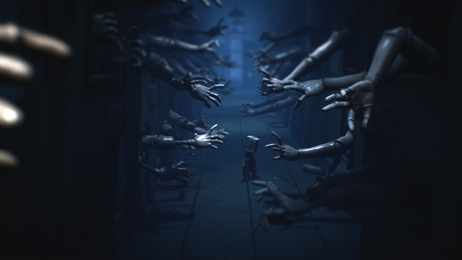 Promotional screenshot of Mono walking through a hall with doll hands in Little Nightmares II