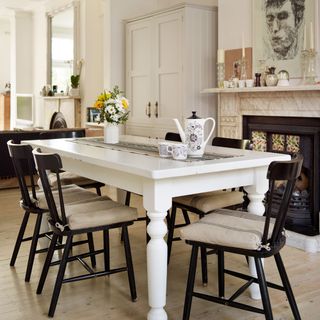 monochrome dining room with a white wooden table and black chairs