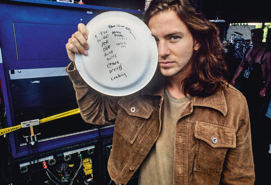 Eddie Vedder holding a Pearl Jam setlist written on a paper plate