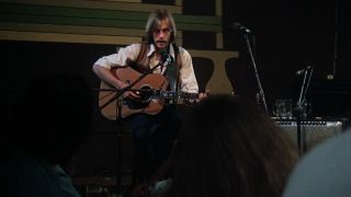 A man playing a guitar on stage in Nashville