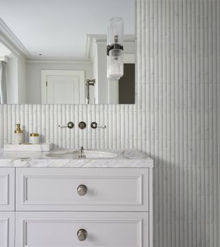 white fluted bathroom tiles with white vanity unit