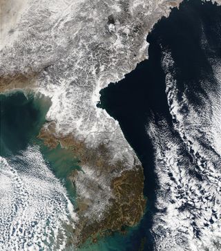 A blanket of white snow covers North Korea, dipping across the Demilitarized Zone into South Korea.