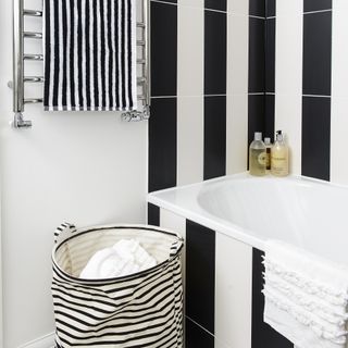 bathroom with bathtub and white with black striped walls