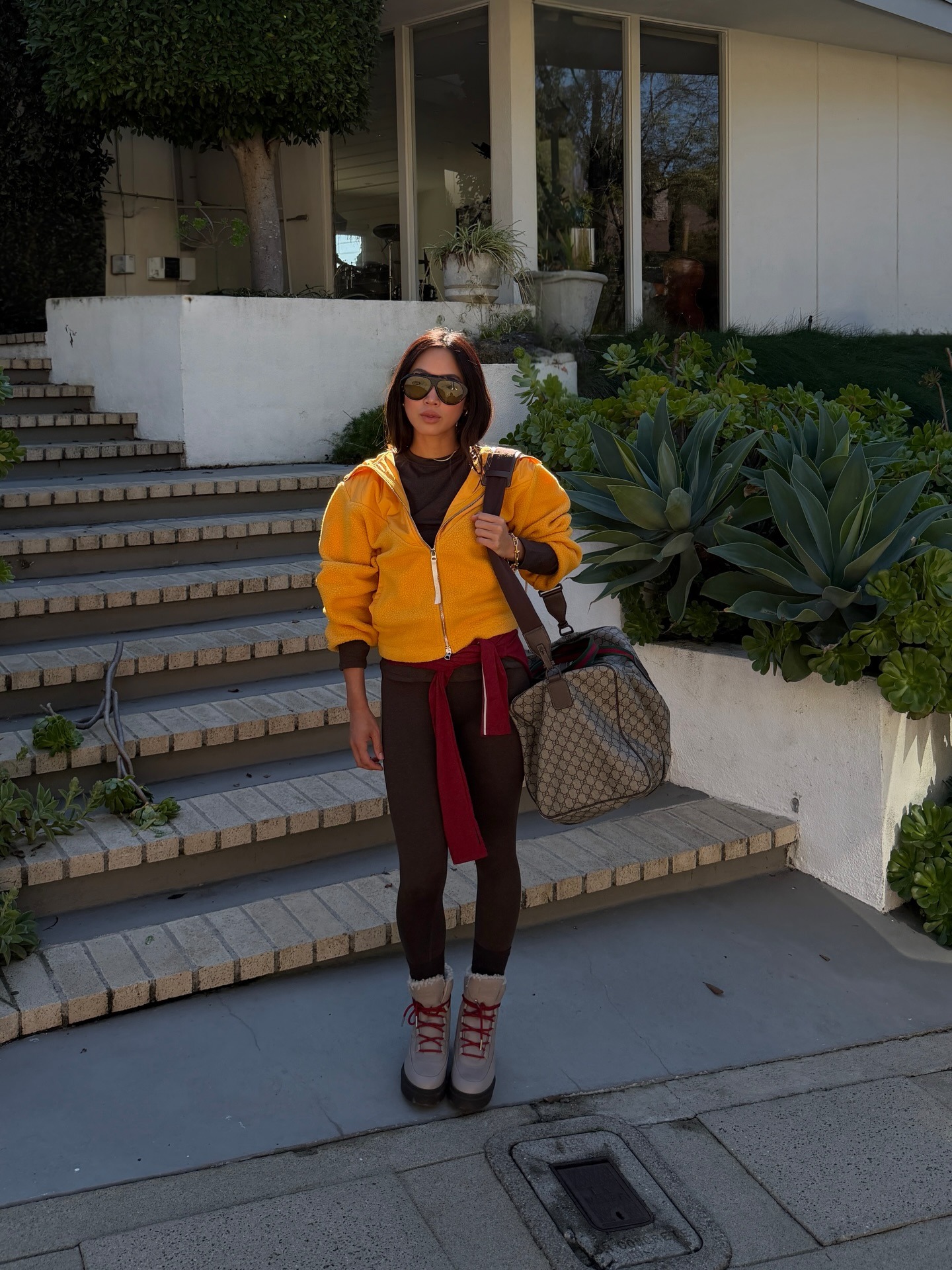 Woman in brown leggings and a yellow sweater.