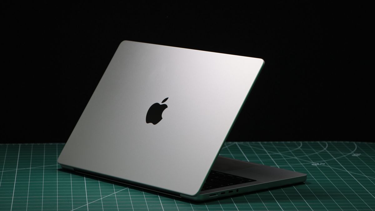 MacBook Pro 14-inch (2023) in a studio with lid partially closed showing Apple logo