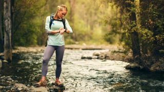 Woman checking GPS sports watch during hike