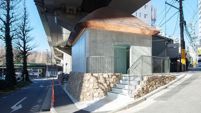 marc newson's contribution to the tokyo toilet project is a concrete structure under a bridge