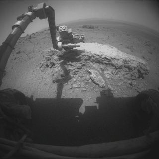 This image shows the Mars rover Opportunity's robotic arm reaching out to the rock Tilsdale 2 at the huge crater Endeavour on the Martian surface on Aug. 23, 2011.