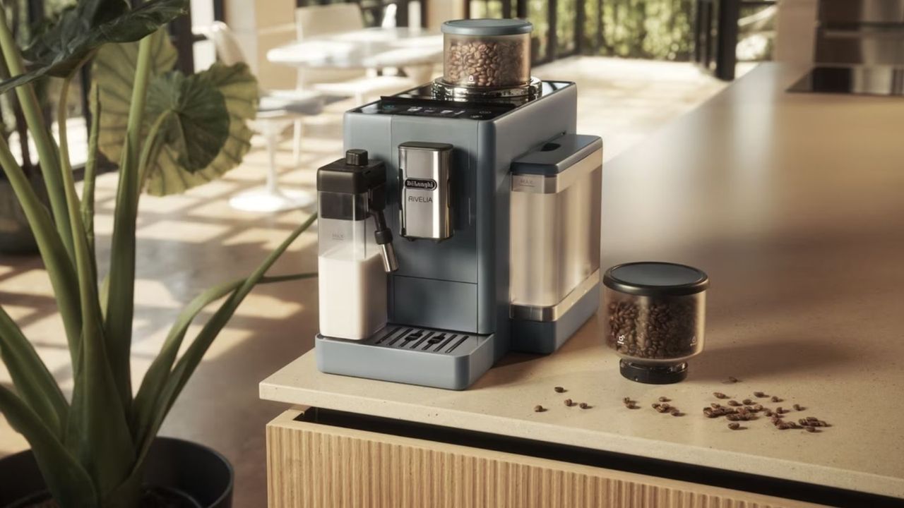 De&#039;Longhi Rivelia on a countertop with coffee beans around it