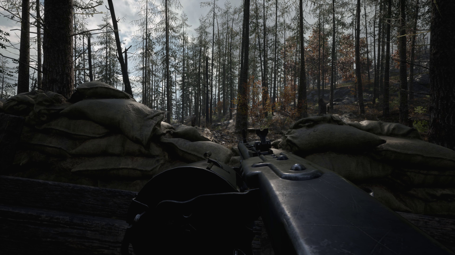 A player hiding behind a wall of sandbags in the woods during one of the best games like Battlefield, Hell Let Loose.