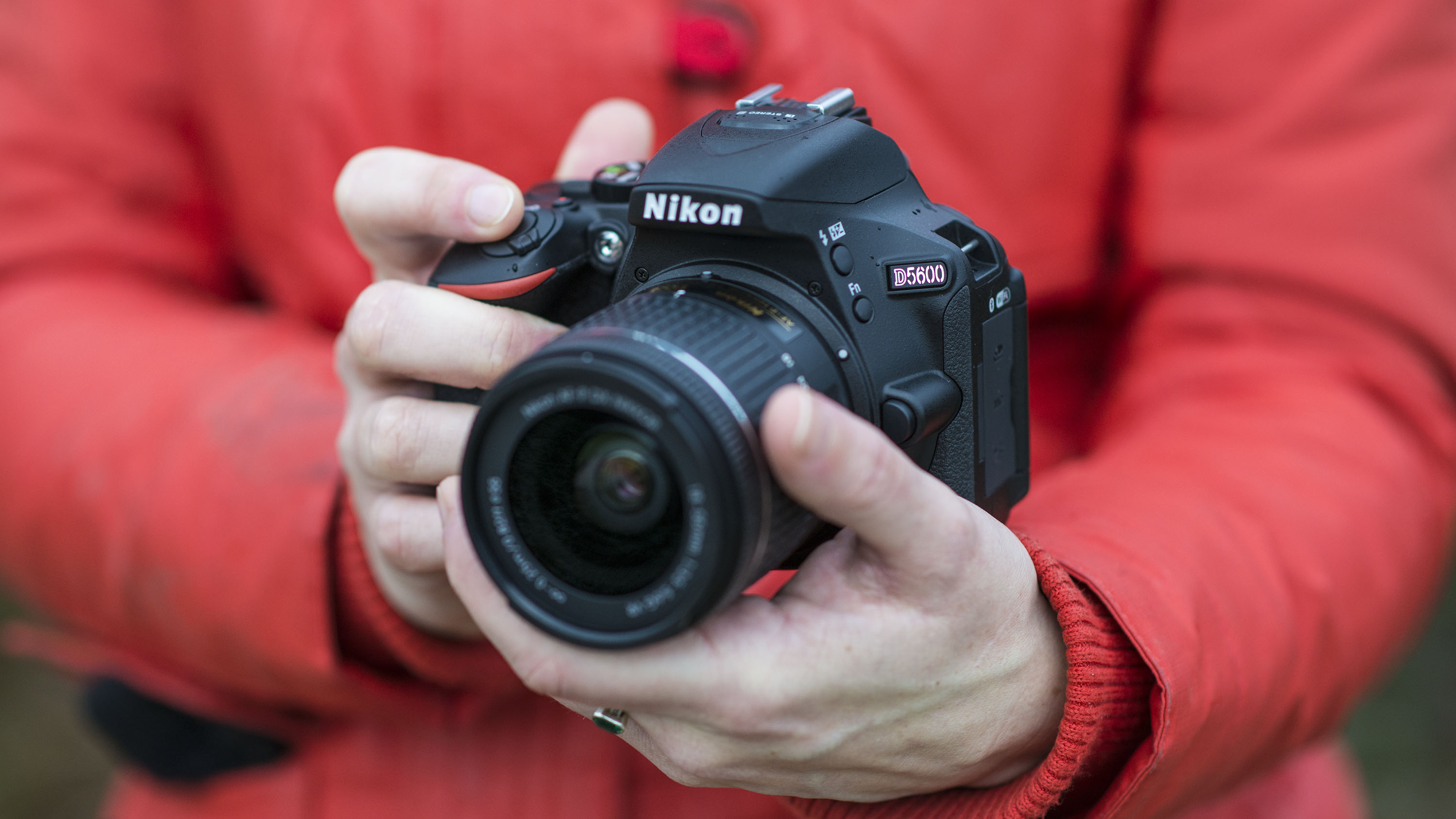 Two hands holding a Nikon D5600 DSLR