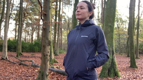 Julia Clarke wearing the Montane Phase Lite Waterproof Jacket in the woods