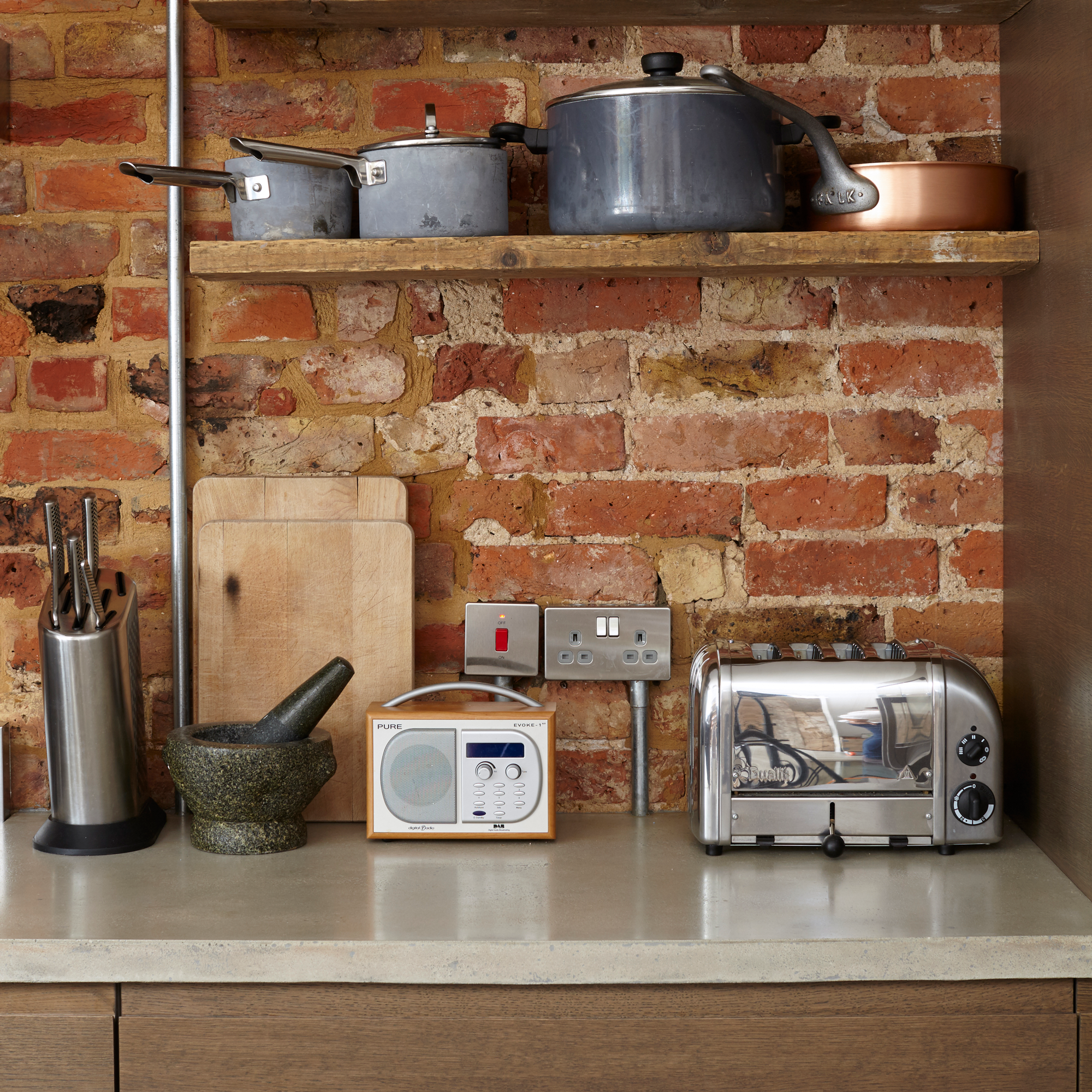 kitchen area with brick wall and toaster