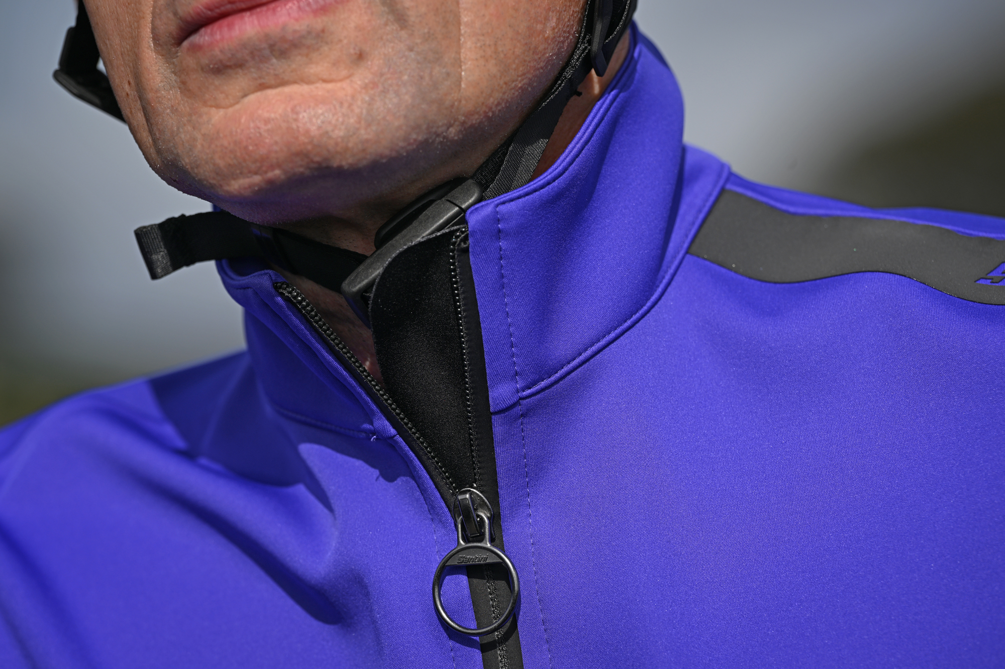 close up of the zip nd high collar on a purple cycling jacket