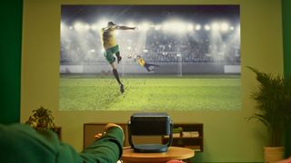 Epson EF-22 projector in a living room displaying a dramatic football match