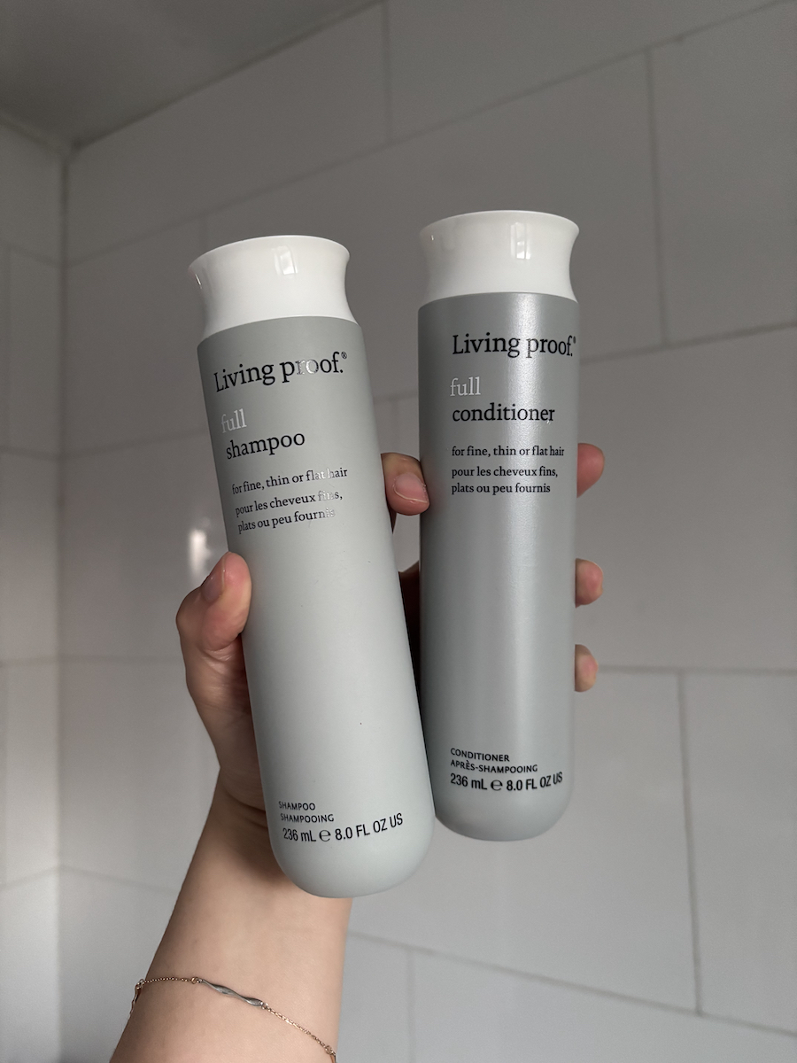 Mica Ricketts holding Living Proof Full Shampoo and Conditioner