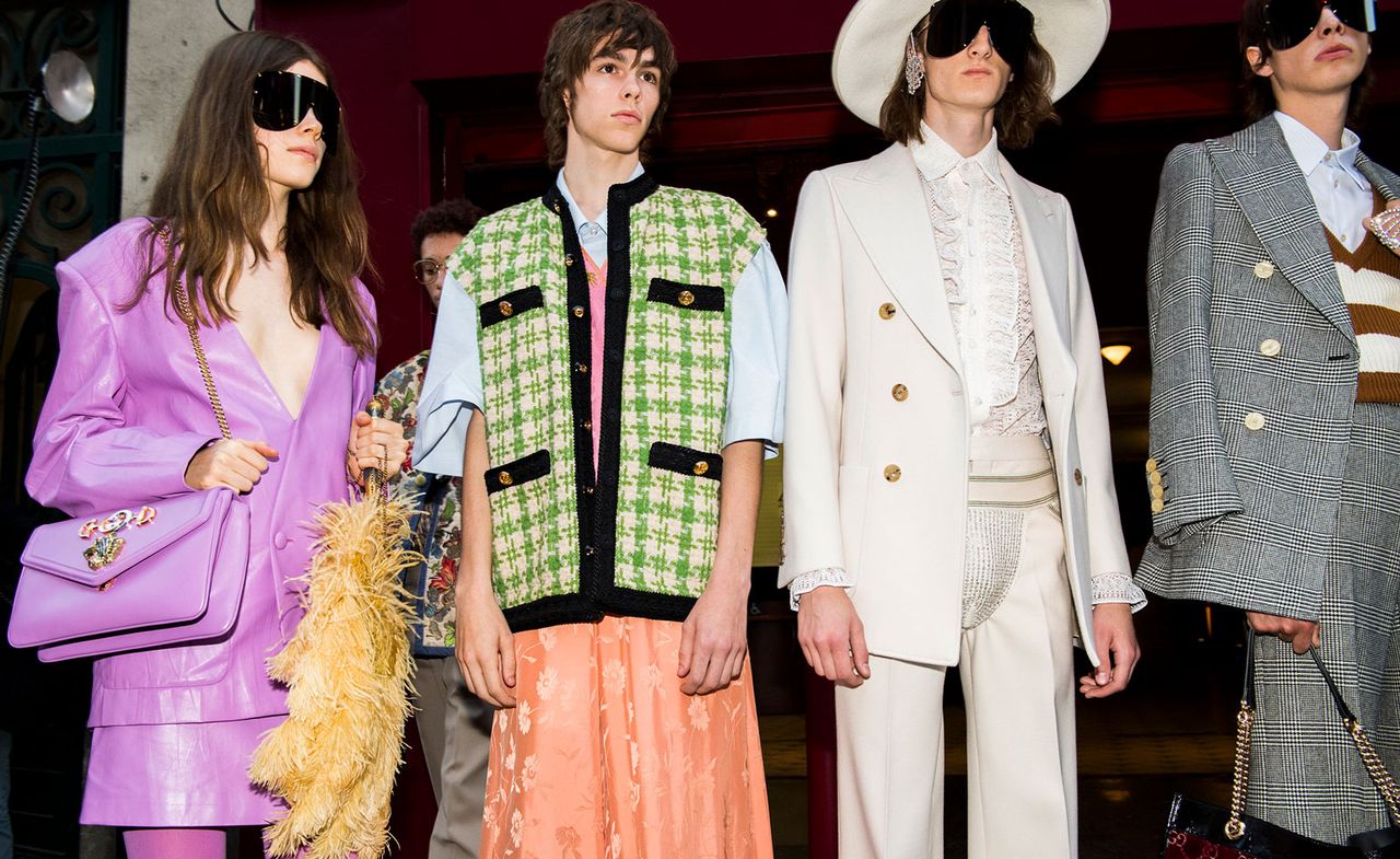 Models wear purple suit, green jacket with orange skirt, white suit and grey blazer