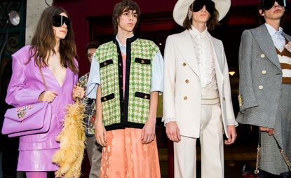 Models wear purple suit, green jacket with orange skirt, white suit and grey blazer