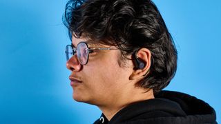 EarFun OpenJump open-ear earbuds photographed in front of a blue background.