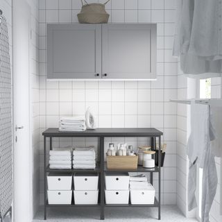 Ikea freestanding storage unit in a laundry room with a wall cupboard