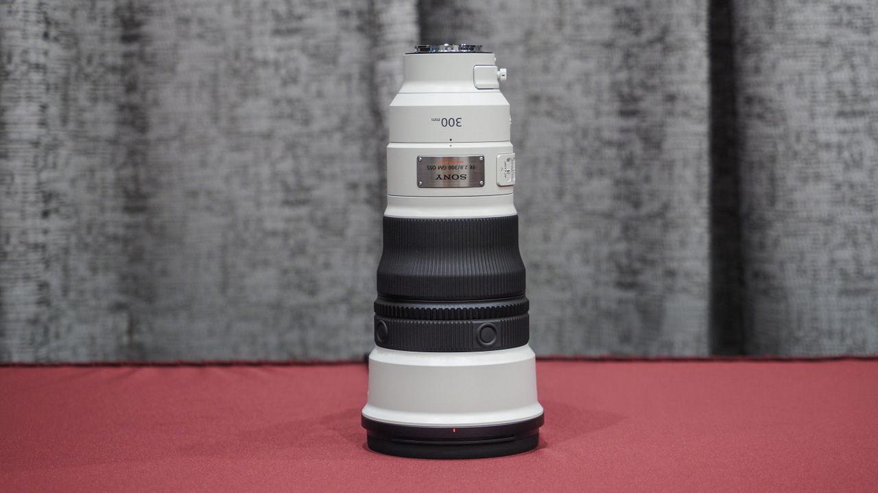 Sony FE 300mm f/2.8 GM OSS lens on a red table with grey curtains