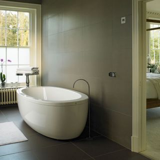 room with white bathtub and tiled flooring