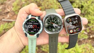 Close-up of the Samsung Galaxy Watch Ultra 2, Apple Watch Ultra 3 and Garmin Instinct 3 in nature